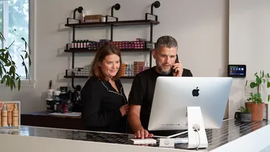 2 people at the salon's front desk